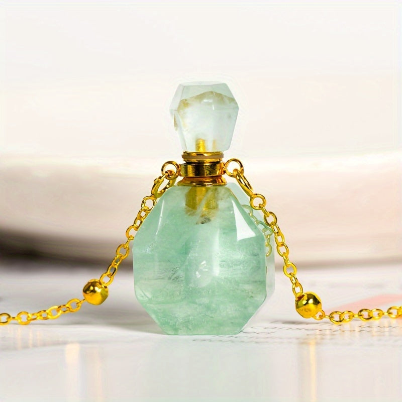 Green natural crystal perfume bottle pendant and chain sitting on a magazine page. 