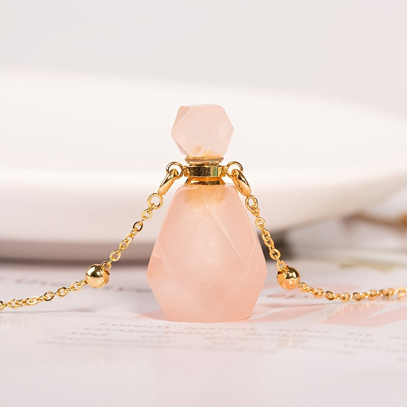 Pink natural crystal perfume bottle pendant and chain sitting on a magazine page