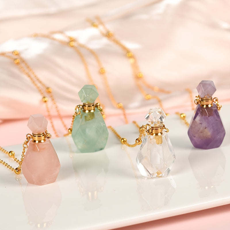 Natural crystal perfume bottle pendant necklaces displayed in multiple color options, pink, green, clear, purple sitting upright on a polished white surface with pink fabric.
