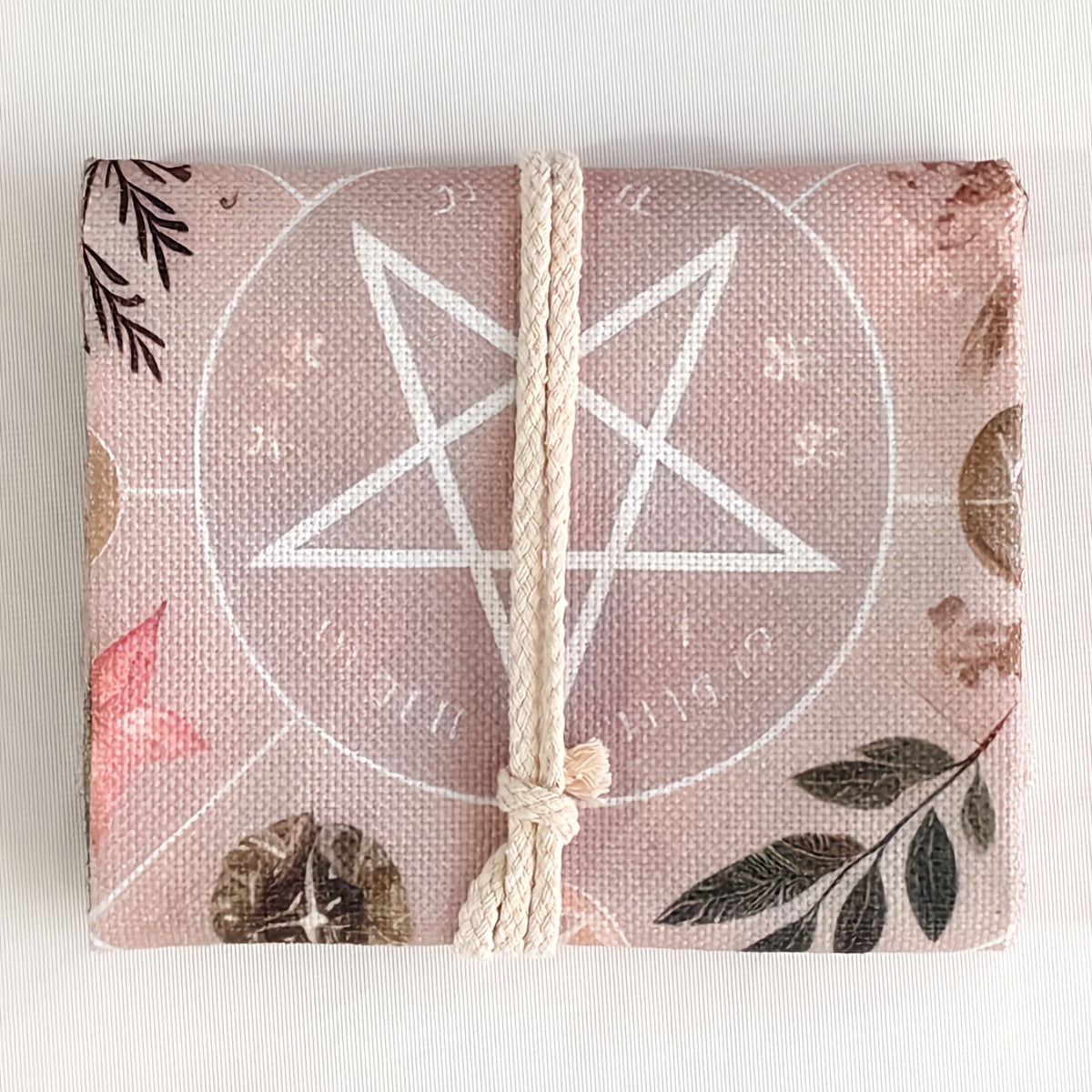 Product with a pentacle design and floral elements on a pink background