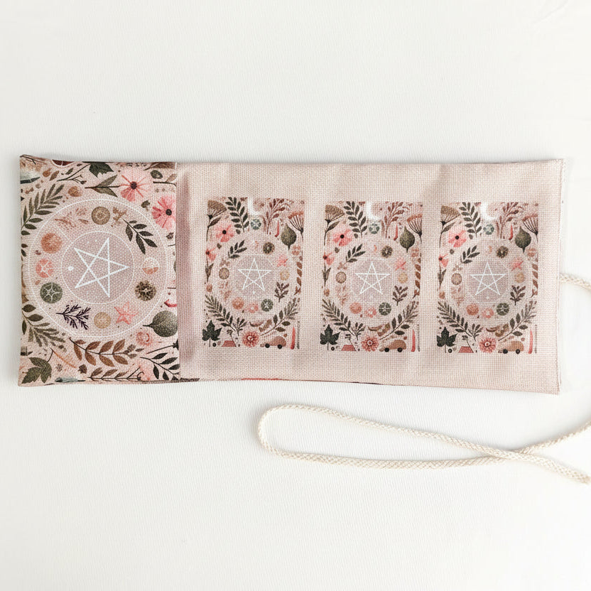Pink floral and pentacle patterned pouch with a strap on a white background