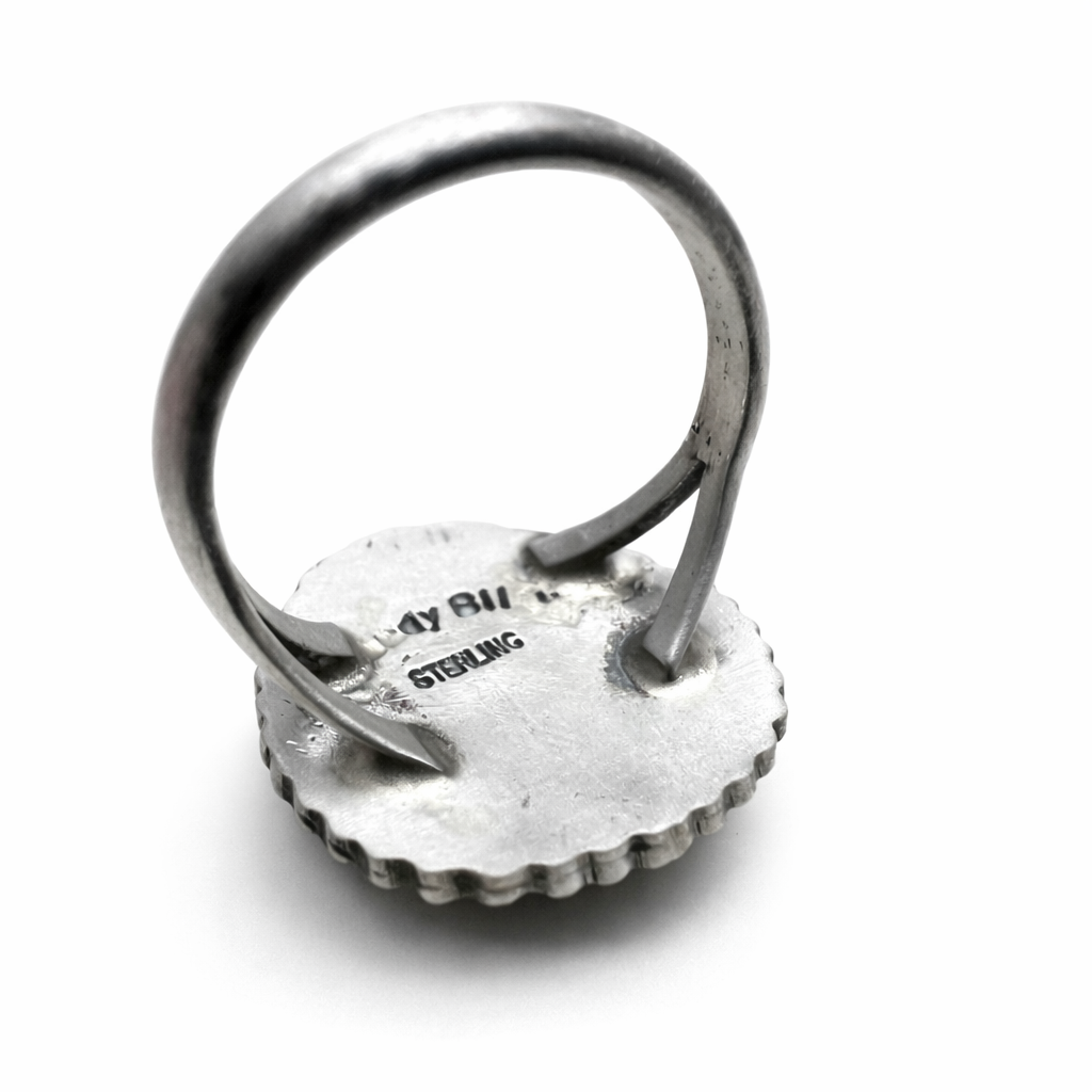 A hallmark Randy Billy sterling on the backside of a ring sitting on a white background.
