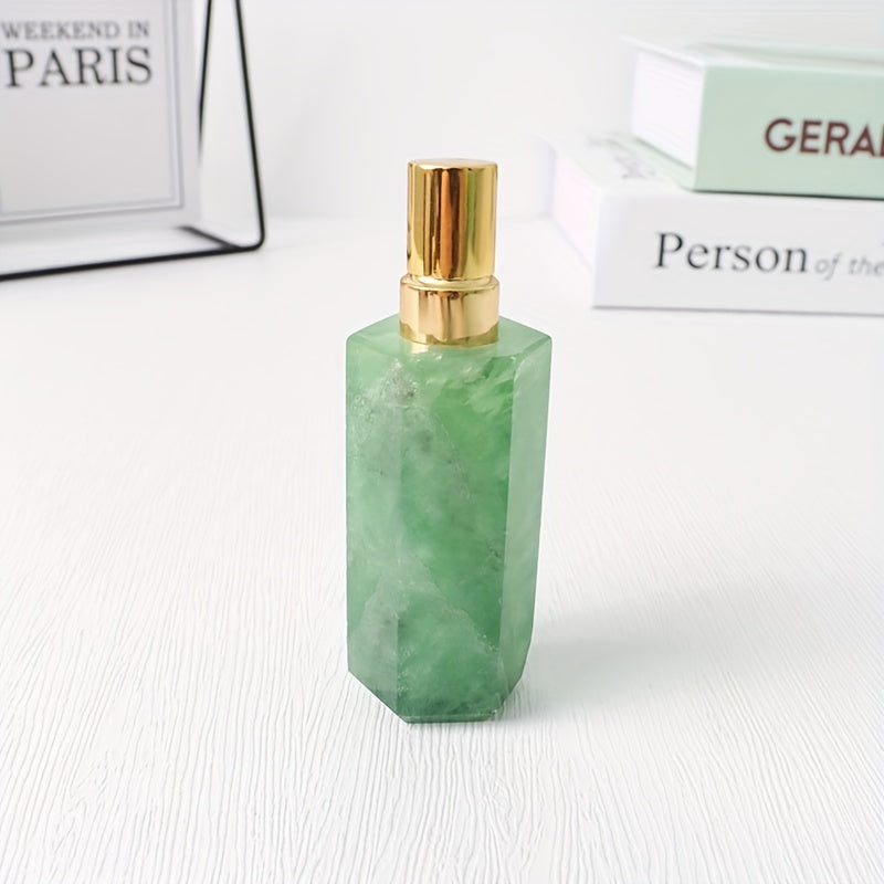 A light green refillable natural crystal stone perfume bottle with stainless steel spray pump on a white background by a stack of books.