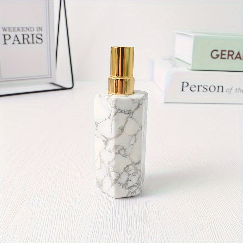 A white refillable natural crystal stone perfume bottle with stainless steel spray pump on a white background by a stack of books.