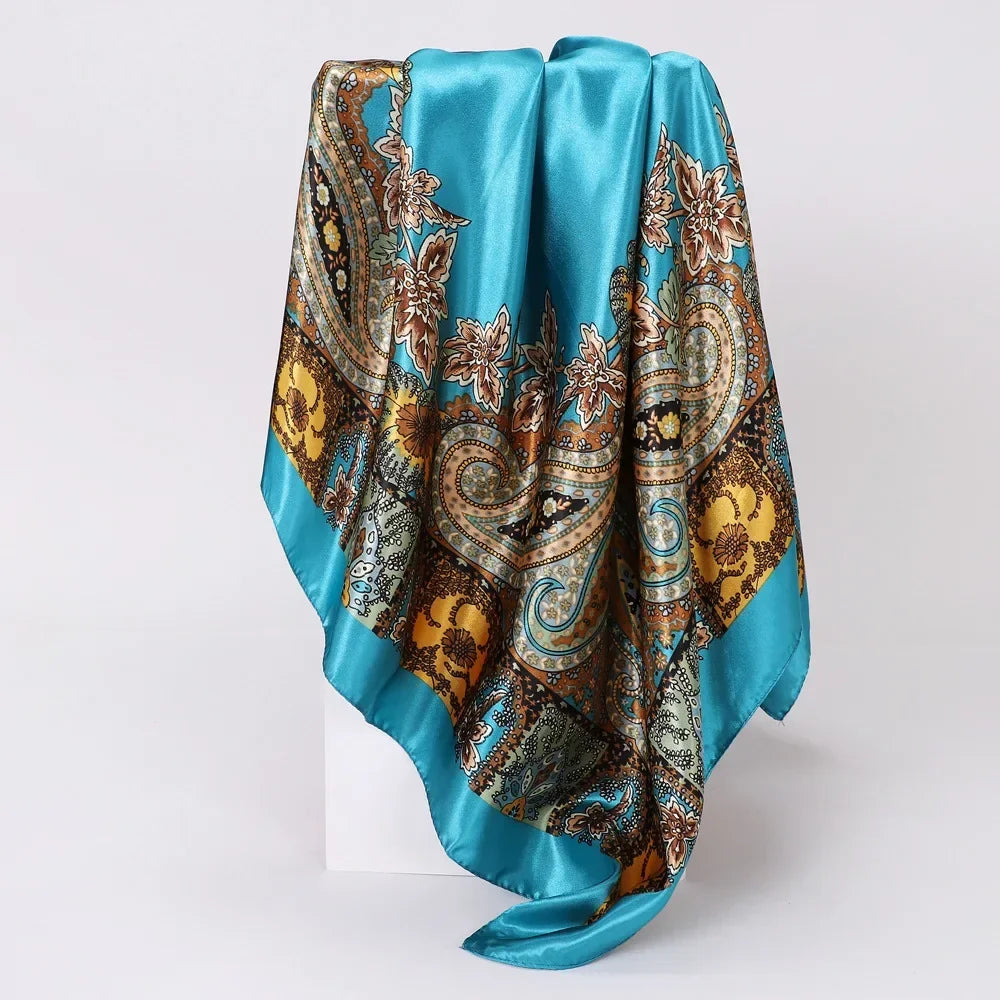 Turquoise silk scarf with intricate paisley pattern on a white background