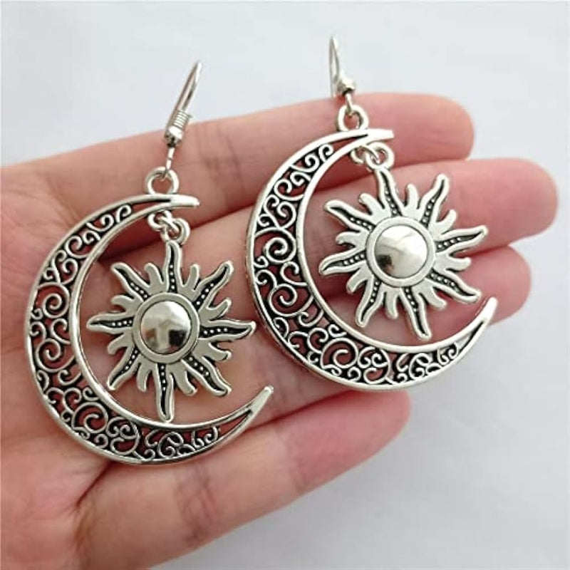 Silver moon and sun dangle earrings with ornate crescent design and polished alloy finish