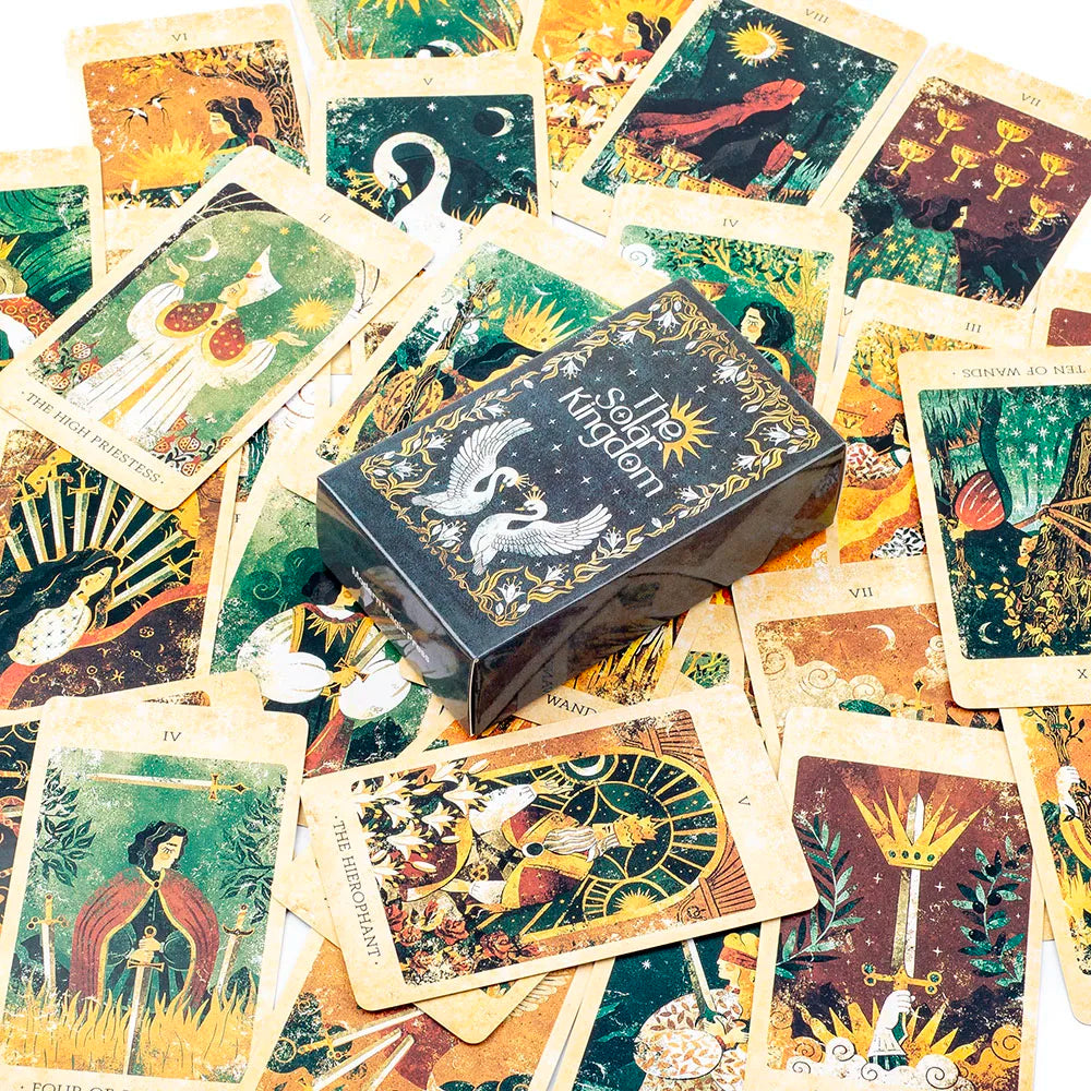 Collection of tarot cards with a box labeled 'Solar Kingdom' on a wooden surface.