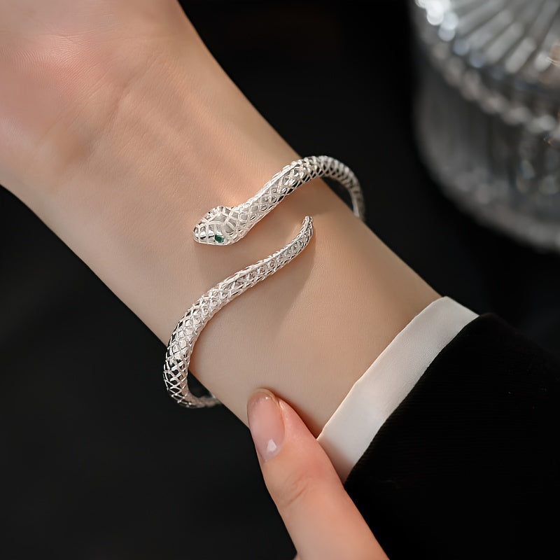 925 Silver Snake Bracelet with Cubic Zirconia worn on a thin wrist wearing long black sleeves on a black background.