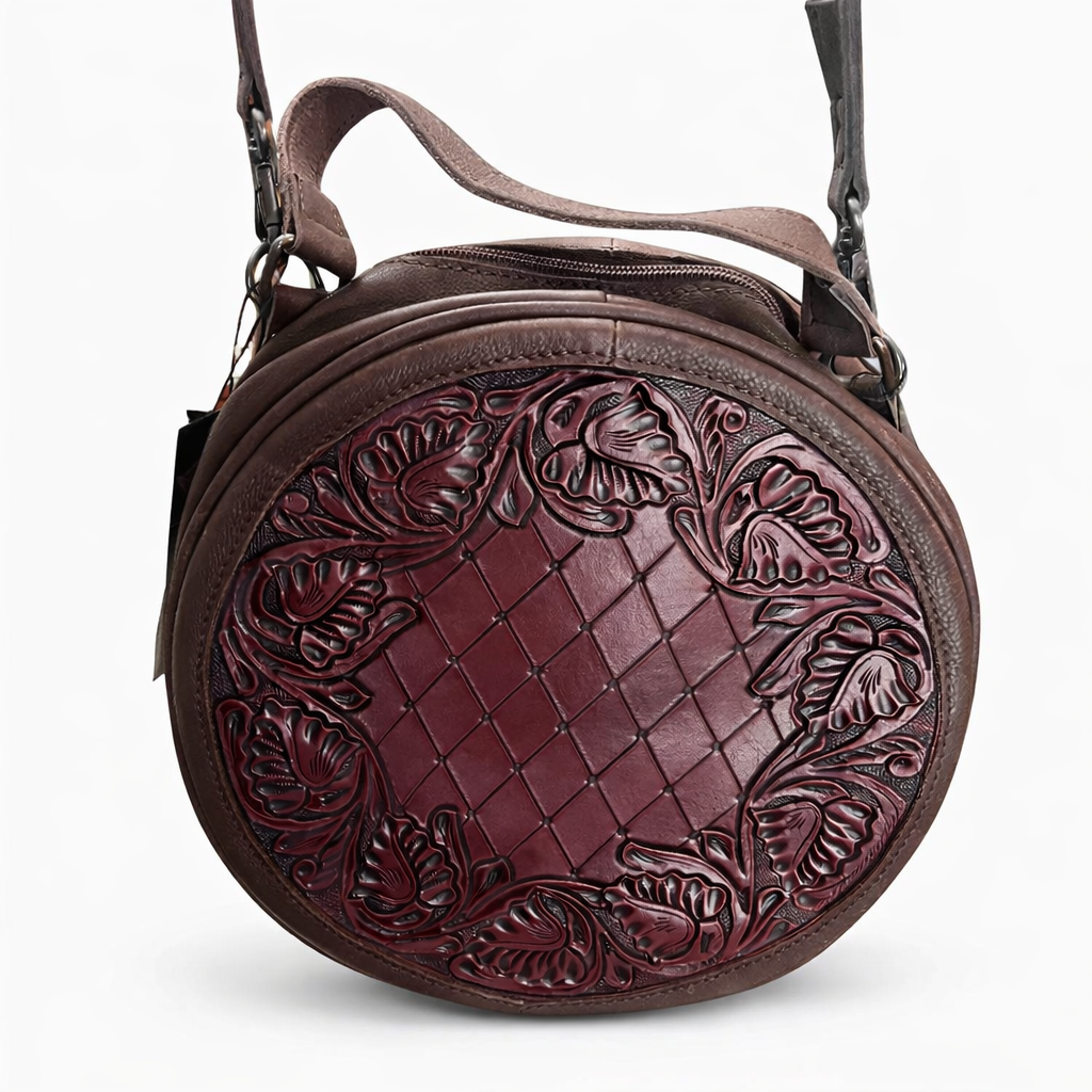 Brown leather handbag with intricate embossed design on a white background
