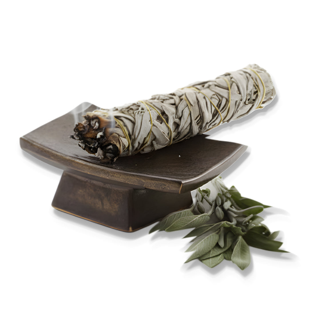 Sage bundle on a wooden holder with sage leaves on a white background