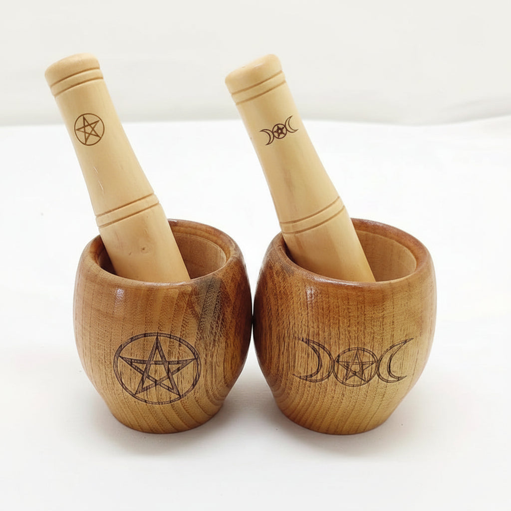 Two wooden mortars and pestles with pentacle and moon designs on a white background