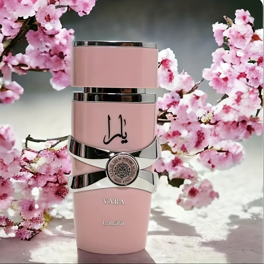 A Yara Eau De Perfume 100 ml pink bottle with silver detail with a cherry blossom floral background.
