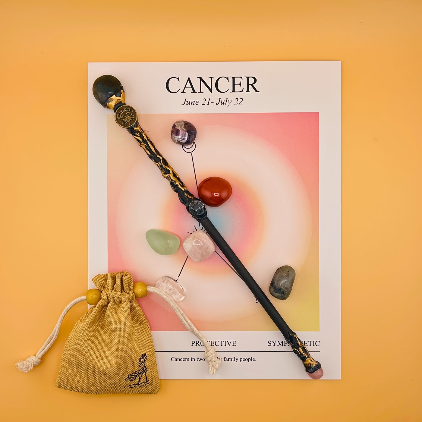 Decorative wand with crystals on a Cancer zodiac poster with a yellow background